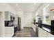 Modern kitchen featuring stainless steel appliances, black countertops, and sleek white cabinetry at 1015 N Beville Ave, Indianapolis, IN 46201