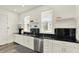 Modern kitchen with white cabinets, black countertop, open shelving, and stainless steel appliances at 1015 N Beville Ave, Indianapolis, IN 46201
