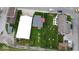 A bird's-eye view of a red house among commercial buildings and greenery, with parking and street access at 104 W Pearl St, Trafalgar, IN 46181