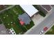 Overhead shot of a red home, with a gray roof, adjacent to a commercial property at 104 W Pearl St, Trafalgar, IN 46181