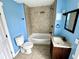 A bathroom features a tiled shower, toilet, vanity, and blue walls at 104 W Pearl St, Trafalgar, IN 46181
