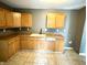 A kitchen featuring wooden cabinetry, laminate countertops, a black faucet, and tile flooring at 104 W Pearl St, Trafalgar, IN 46181
