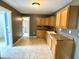 An open kitchen features tile flooring, wooden cabinets, a sink, and an adjacent doorway at 104 W Pearl St, Trafalgar, IN 46181