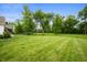 Spacious backyard featuring a well-maintained lawn and mature trees at 10505 Golden Bear Way, Noblesville, IN 46060