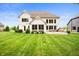 Expansive backyard view showcasing the home's exterior, deck, and lush green lawn at 10505 Golden Bear Way, Noblesville, IN 46060
