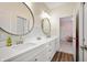 Bathroom features dual sinks and faucets, round mirrors, modern lighting, and white shaker cabinets at 10505 Golden Bear Way, Noblesville, IN 46060