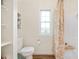 Bathroom featuring a window, a toilet, wooden floors, and a shower with a patterned curtain at 10505 Golden Bear Way, Noblesville, IN 46060