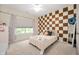 Bright bedroom features an accent wall with a checkerboard pattern, plush carpeting, and plenty of light at 10505 Golden Bear Way, Noblesville, IN 46060