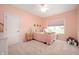 Bright pink bedroom featuring a cozy bed, a window with blinds, and soft carpeting at 10505 Golden Bear Way, Noblesville, IN 46060