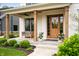 Inviting front porch with wooden columns, a cozy bench swing, and a stylish wooden door at 10505 Golden Bear Way, Noblesville, IN 46060