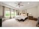 Serene main bedroom with tray ceilings, plush carpeting, and scenic backyard views at 10505 Golden Bear Way, Noblesville, IN 46060