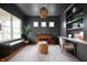Sophisticated office with dark walls, built-in shelving, large window, and unique lighting fixture at 10505 Golden Bear Way, Noblesville, IN 46060