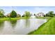 Scenic view of the pond with a fountain, surrounded by lush green grass and mature trees at 10505 Golden Bear Way, Noblesville, IN 46060