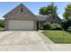 Charming brick home with attached garage and manicured lawn, offering curb appeal and functionality at 11014 Lake Run Dr, Fishers, IN 46038