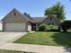 Charming brick home with attached garage and manicured lawn, offering curb appeal and functionality at 11014 Lake Run Dr, Fishers, IN 46038