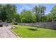 Landscaped backyard featuring a hammock, stone pavers, lush lawn, and a wood fence at 11041 Limbach Cir, Indianapolis, IN 46236