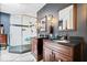 Bathroom showcasing a glass shower, dark granite countertops, and and vanities at 11041 Limbach Cir, Indianapolis, IN 46236