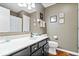 Neutral toned bathroom featuring a black vanity, white countertop and decorative framed prints on the walls at 11041 Limbach Cir, Indianapolis, IN 46236