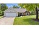 Charming single-story home featuring a two-car garage and a well-manicured lawn at 11041 Limbach Cir, Indianapolis, IN 46236