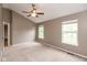 Bedroom featuring two bright windows, a ceiling fan, and spacious closet at 11051 Oakridge Dr, Fishers, IN 46038