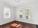 This bedroom features warm hardwood floors, two windows, and crisp white walls at 1209 W 22Nd St, Anderson, IN 46016