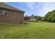 The large backyard of this single-Gathering home features green grass and a deck at 121 George Ct, Danville, IN 46122