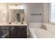 Bathroom featuring a double vanity, soaking tub, and a modern shower curtain for privacy at 121 George Ct, Danville, IN 46122