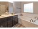 Bathroom featuring a double vanity, soaking tub, and a modern shower curtain for privacy at 121 George Ct, Danville, IN 46122