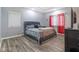 Bedroom with a queen-size bed, gray bedding, windows with red curtains, and a modern tray ceiling at 121 George Ct, Danville, IN 46122
