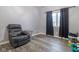 Bedroom with wood-look floors, a chair, and a window with dark curtains at 121 George Ct, Danville, IN 46122