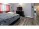 Bedroom featuring wood-look floors, red curtains, a TV on a dresser, and neutral walls at 121 George Ct, Danville, IN 46122