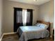 A cozy bedroom features a full-sized bed, dark curtains, and wood floors at 121 George Ct, Danville, IN 46122