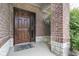Covered front porch showing the brick base and wood door at 121 George Ct, Danville, IN 46122