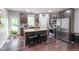 This open kitchen features a large island, stainless steel appliances, dark cabinets, and a view to the deck at 121 George Ct, Danville, IN 46122