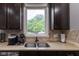 A close up of the kitchen features a sink with a view, mosaic tile backsplash, and stainless appliances at 121 George Ct, Danville, IN 46122