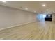 Expansive basement with modern bar area, light vinyl floors, and ample space for entertaining at 1305 Gleneagle Dr, Indianapolis, IN 46239