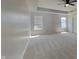 Bright bedroom showcasing neutral carpeting, tray ceiling, and ample natural light at 1305 Gleneagle Dr, Indianapolis, IN 46239