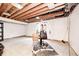 Spacious unfinished basement with exposed wood beams, exercise machine, and concrete floor ready for customization at 1306 Flat Wood Ct, Brownsburg, IN 46112