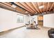 Unfinished basement featuring exposed beams, an exercise machine, concrete floor, and a single window at 1306 Flat Wood Ct, Brownsburg, IN 46112