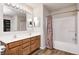 Bathroom features double vanity, shower-tub combo with decorative curtain, and modern lighting at 1306 Flat Wood Ct, Brownsburg, IN 46112