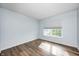 Bedroom features hardwood floors, soft blue walls, a window with shades, and bright natural light at 1306 Flat Wood Ct, Brownsburg, IN 46112