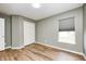 Bedroom features wood-look flooring, double-door closet, a window with shades, and light gray walls at 1306 Flat Wood Ct, Brownsburg, IN 46112
