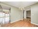 Charming dining area featuring hardwood floors, neutral walls, chandelier, and view into living spaces at 1306 Flat Wood Ct, Brownsburg, IN 46112