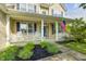 Charming front porch with white railings, blue shutters, an American flag, and manicured landscaping at 1306 Flat Wood Ct, Brownsburg, IN 46112