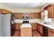 Bright kitchen featuring stainless steel appliances, wood cabinets, granite countertops, and hardwood floors at 1306 Flat Wood Ct, Brownsburg, IN 46112