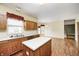 Spacious kitchen with island, wood cabinets, hardwood flooring, stainless steel appliances, and natural light at 1306 Flat Wood Ct, Brownsburg, IN 46112