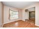 Welcoming living room with hardwood floors, a window with curtains, and view into the dining room at 1306 Flat Wood Ct, Brownsburg, IN 46112