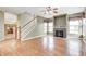 Spacious living room featuring hardwood floors, a fireplace, stairs, windows and a ceiling fan at 1306 Flat Wood Ct, Brownsburg, IN 46112