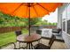 Patio with outdoor seating area with a colorful orange umbrella and lush green lawn at 13817 Black Canyon Ct, Fishers, IN 46038