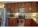 Kitchen showcasing stainless steel appliances and wooden cabinets, with ample counter space at 13817 Black Canyon Ct, Fishers, IN 46038